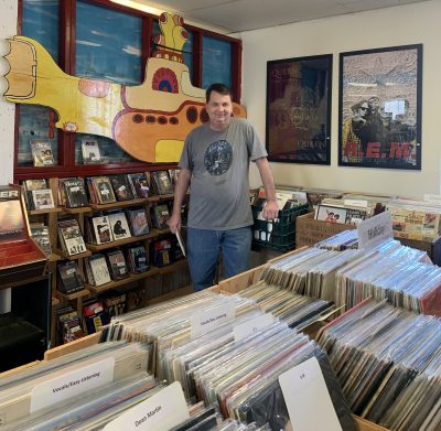 Chris Bugbee standing in his record store.