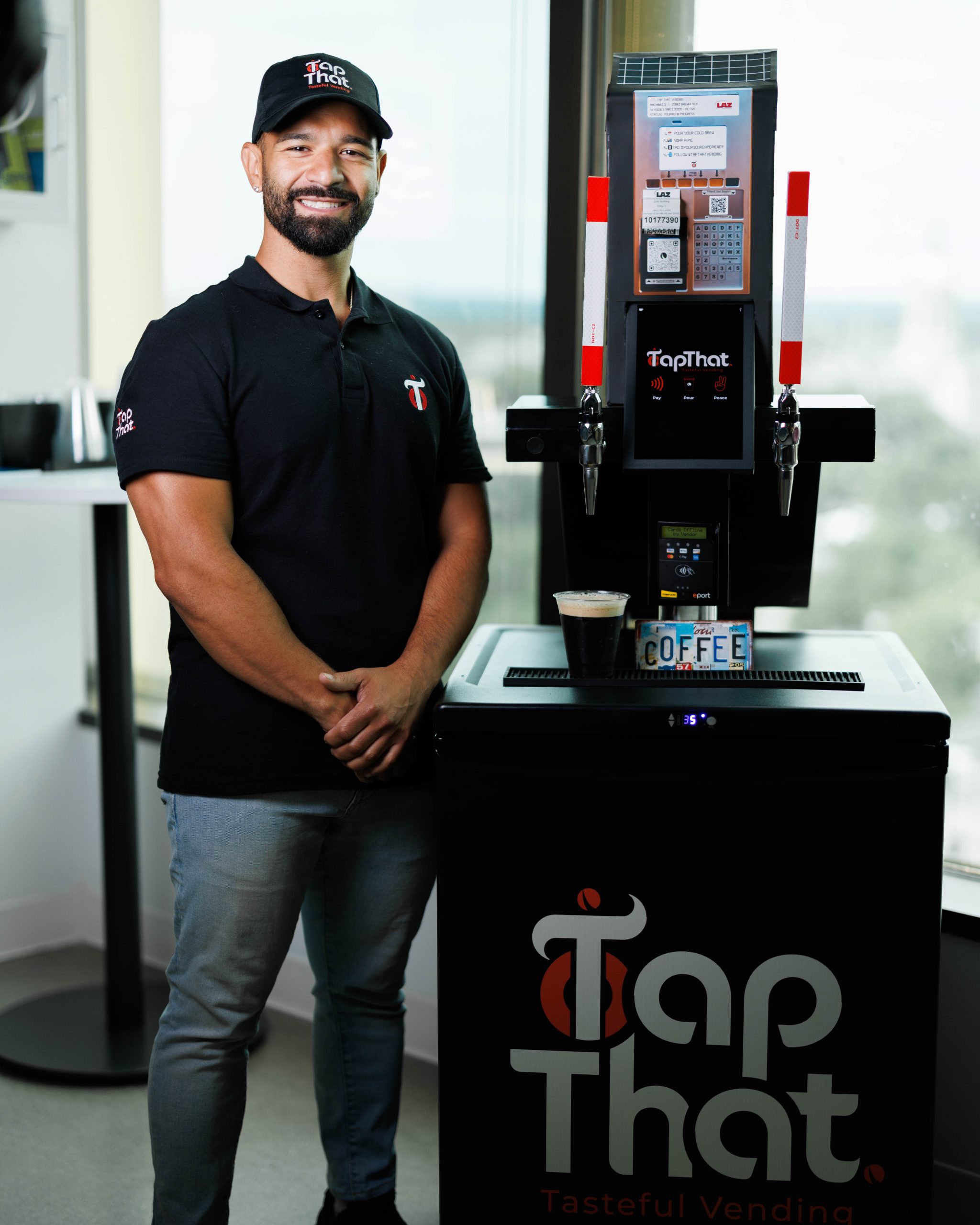 Michael Palladini standing next to a TapThat Vending machine