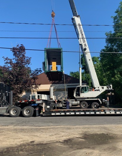 A crane lifting a pallet making machine