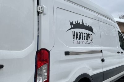 A picture of Hartford Film Company's logo on the side of a van.