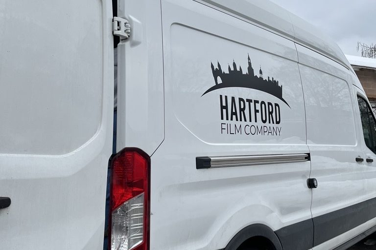 A picture of Hartford Film Company's logo on the side of a van.