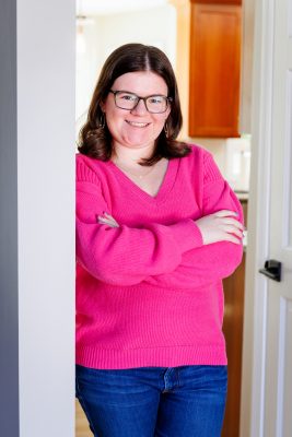 Ciatlyn Grad in a pink sweater leaning in a door