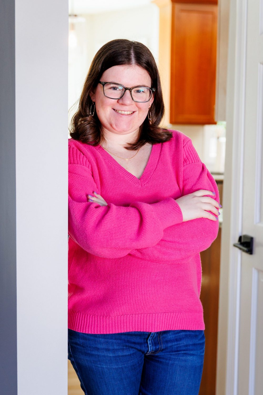 Ciatlyn Grad in a pink sweater leaning in a door