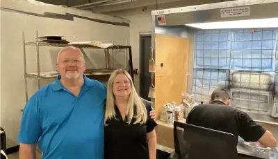 Ron and Cristine Kern standin beside an art restorer working at Prism Specialty Restoration