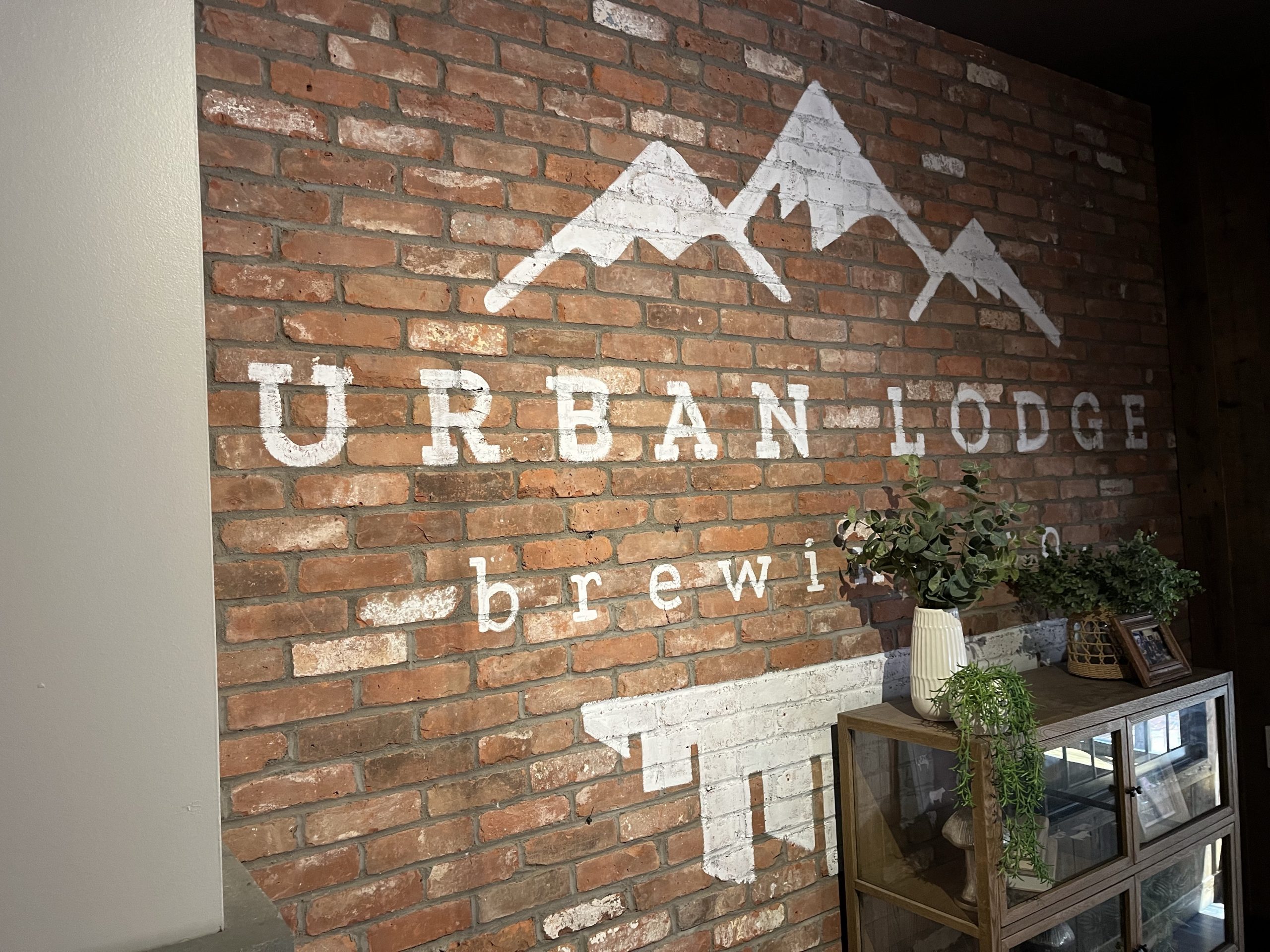 Urban Lodge Logo on a brick wall in the Pratt Street location